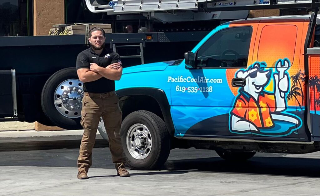 Pacific Heating and Air Conditioning technician standing confidently next to a branded service truck with company graphics.