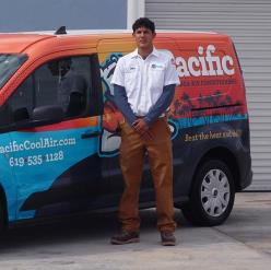 Pacific Heating and Air Conditioning technician standing in front of a company-branded service van, ready for HVAC service.